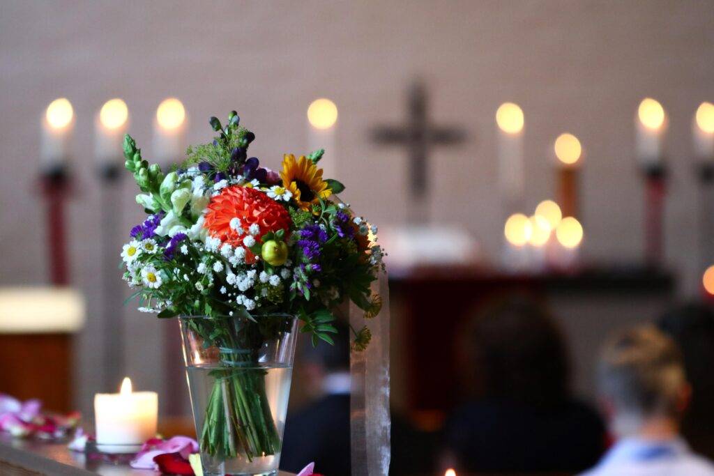 Blumenstrauß in einer Vase und Kerzenlicht bei einer Taufzeremonie