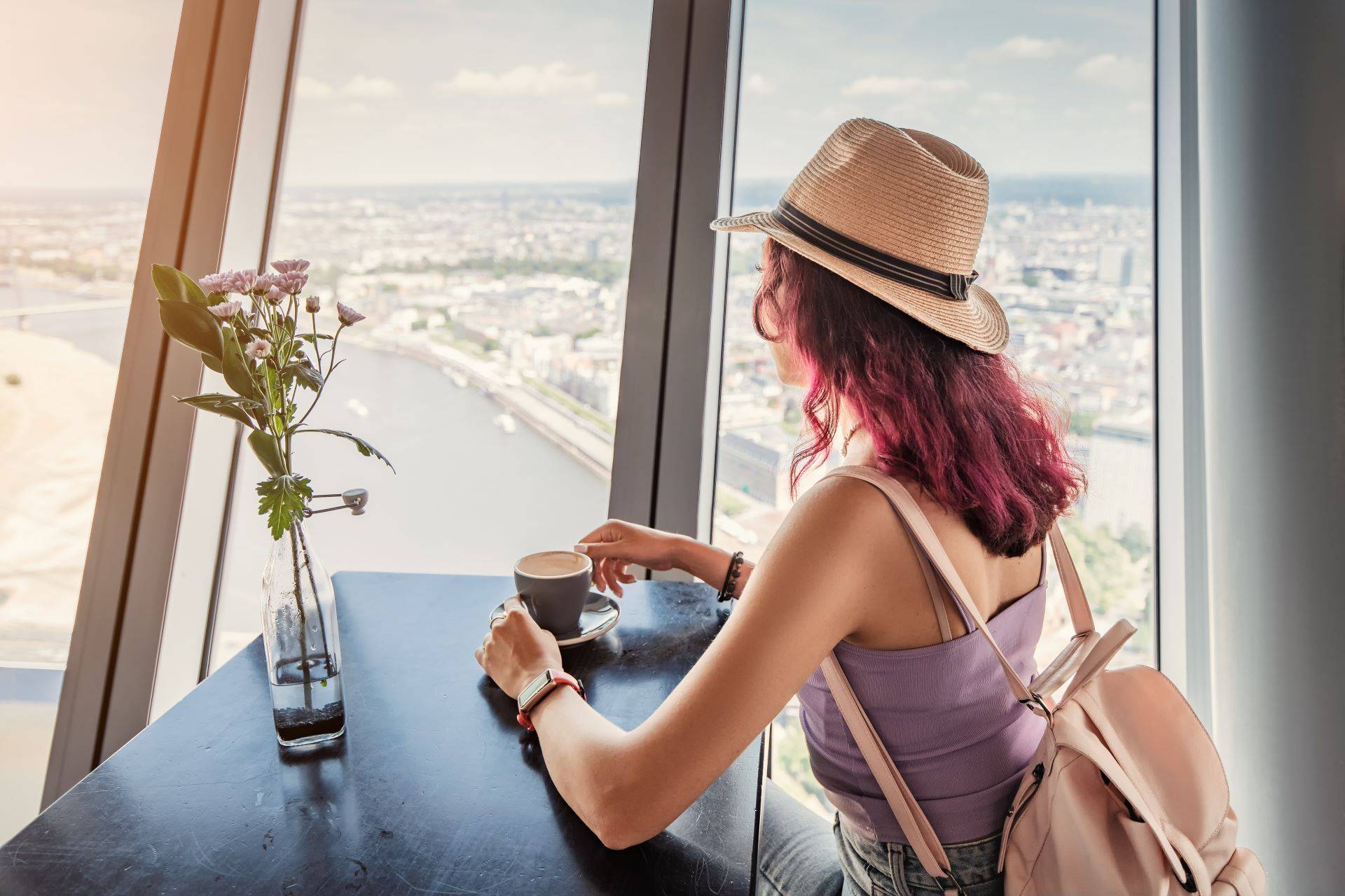 Frau genießt Kaffee mit Blick auf den Rhein aus dem Rheinturm in Düsseldorf